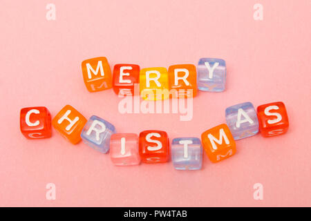 words merry christmas made of colorful blocks on pink background. Flat lay, top view - holidays, winter, christmas and new year celebration concept Stock Photo