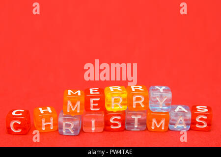words merry christmas made of colorful blocks on red background. Flat lay, top view - holidays, winter, christmas and new year celebration concept Stock Photo