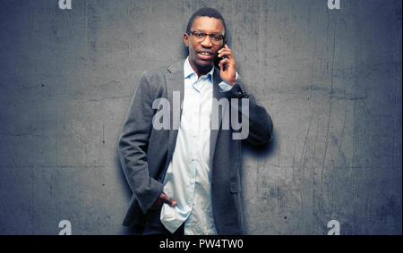 African black man wearing jacket happy talking using a smartphone mobile phone Stock Photo