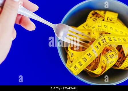 The concept of the diet. The fork rewound centimeter lying on plate Stock Photo