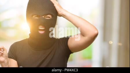 Burglar terrorist woman wearing balaclava ski mask pointing away side with finger Stock Photo