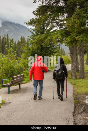 BANFF, AB, CANADA - JUNE 2018: Two people walking on a footpath in Banff. Stock Photo