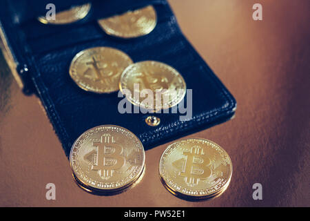 Bitcoins are scattered on the table from wallet Stock Photo