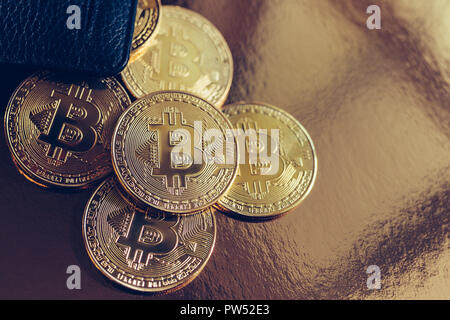 Bitcoins are scattered on the table from wallet Stock Photo