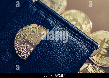 Bitcoins are scattered on the table from wallet Stock Photo