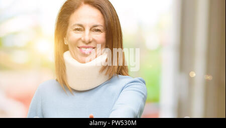 Injured woman wearing neck brace collar holds hands welcoming in handshake pose, expressing trust and success concept, greeting Stock Photo