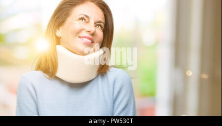 Injured woman wearing neck brace collar thinking and looking up expressing doubt and wonder Stock Photo