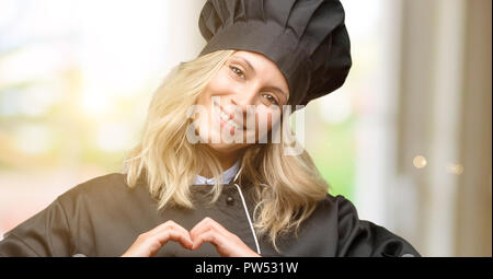 Beautiful cook woman chef happy showing love with hands in heart shape expressing healthy and marriage symbol Stock Photo