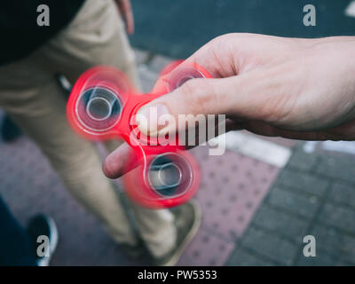 Red fidget spinner spinning in expert hands Stock Photo