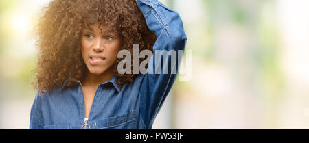 African american woman wearing blue jumpsuit doubt expression, confuse and wonder concept, uncertain future Stock Photo