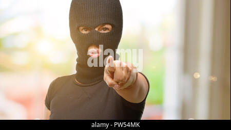 Burglar terrorist woman wearing balaclava ski mask pointing to the front with finger Stock Photo