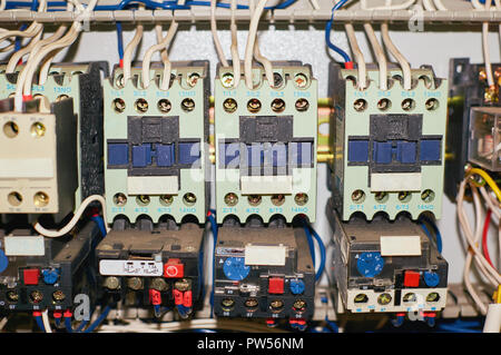 Several old relays with connected colored wires. Industrial background. Stock Photo