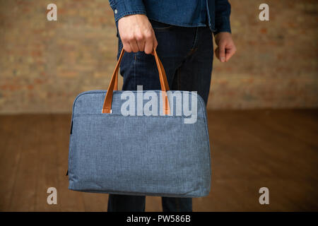 man hold on a textile briefcase for laptop. Close up Stock Photo