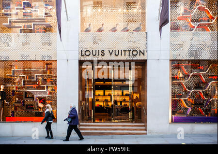 LONDON, UK - NOV 21: People walk in front of the Christmas decorated windows  of the Louis Vuitton boutique in Mayfair, London, UK on November 21, 201 Stock Photo
