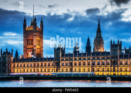 The Houses of Parliament along the river Thames in London at night.