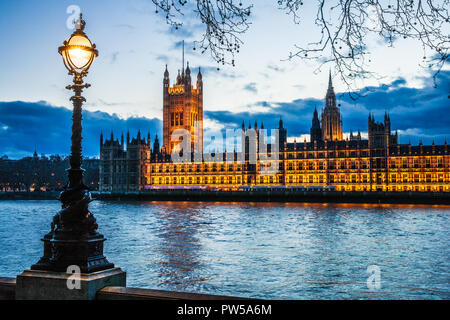 The Houses of Parliament along the river Thames in London at night.