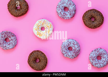 Delicious glazed donuts on pink surface. Flat lay minimalist food art background. Top view. Stock Photo