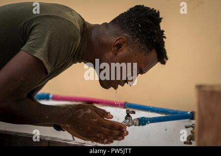 U.S. Marine Jeffrey Decen washes his face after mixing concrete at Esperanza Elementary School in support of KAMANDAG in Casiguran, Aurora, Philippines, Sept. 20, 2017. KAMANDAG has ongoing combined humanitarian and civic assistance activities that enable American and Philippine service members to get to know each other and provide support to local communities. Decen is a fire team leader with Bravo Company, 9th Engineering Support Battalion, 3rd Marine Logisitics Group, and is a native of Newark, New Jersey. Stock Photo