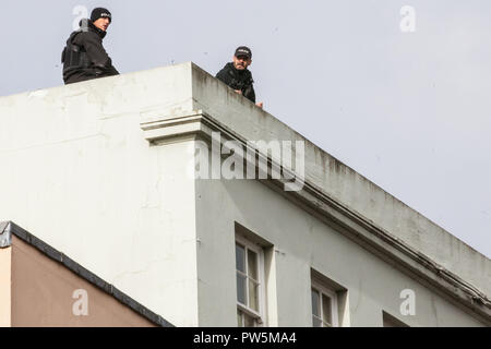 Windsor, UK. 12th October, 2018. Police spotters on a rooftop above the route of the carriage procession to follow the wedding at St George's Chapel of Princess Eugenie, the Queen's granddaughter, and Jack Brooksbank. Credit: Mark Kerrison/Alamy Live News Stock Photo