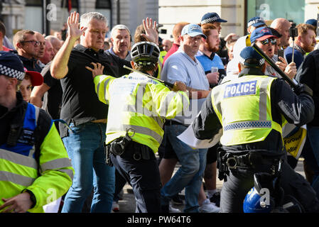 Democratic Football Lads Alliance DFLA marching towards Parliament, London, in protest demonstration. Marchers broke through a police cordon and scuffles took place. Cycle officer with telescopic baton stick Stock Photo