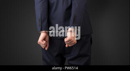Close now arrested men hand with dark background and handcuffs Stock Photo