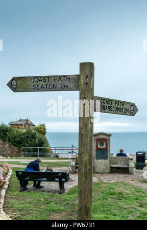 A wooden sign post for the coast path in Beer Village in Devon. Stock Photo