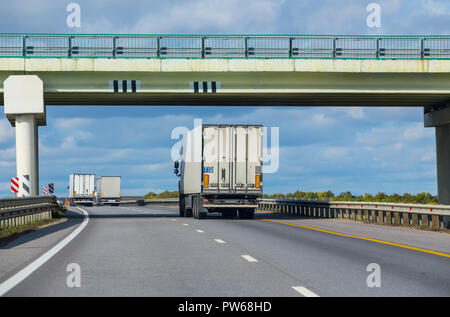 Trucks move under a viaduck. Two-way traffic. Stock Photo