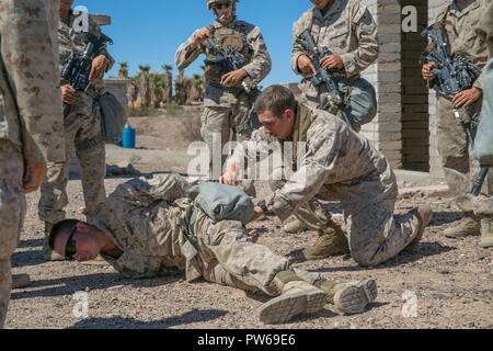 U.S. Marine Corps Pfc. Brett Mason, an infantry assault Marine with Kilo Company, 3rd Battalion, 1st Marines, gives a class on conducting a body search during Weapons and Tactics Instructors Course (WTI) 1-18 at Yuma, Ariz., on Sept. 27, 2017. WTI is a seven week training event hosted by Marine Aviation and Weapons Tactics Squadron One (MAWTS-1) cadre which emphasizes operational integration of the six functions of Marine Corps Aviation in support of a Marine Air Ground Task Force. MAWTS-1 provides standardized advanced tactical training and certification of unit instructor qualifications to s Stock Photo