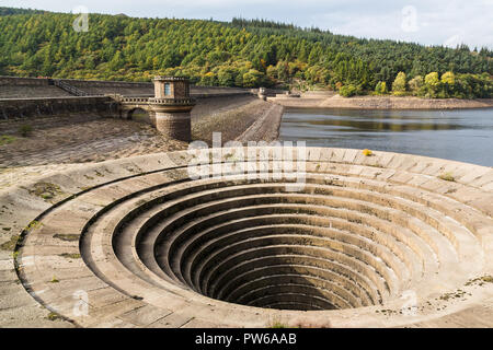 Ladybower Dam at the South side of the Ladybower Reservoir near Bamford in Derbyshire.   Both of the plugholes (bellmouth overflows) were completely o Stock Photo