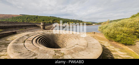 Ladybower Dam at the South side of the Ladybower Reservoir near Bamford in Derbyshire.   Both of the plugholes (bellmouth overflows) were completely o Stock Photo