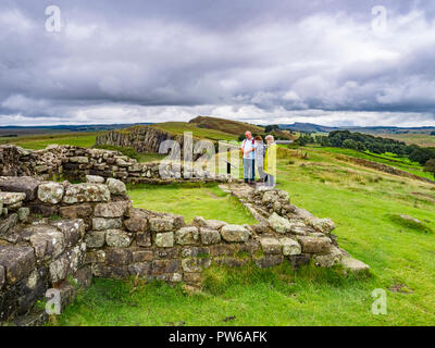 13 August 2018: Hadrian's Wall, Northumberland - Group of walkers at Turret 45A on Hadrians' Wall near Walltown Crags under a dramatic sky. Stock Photo