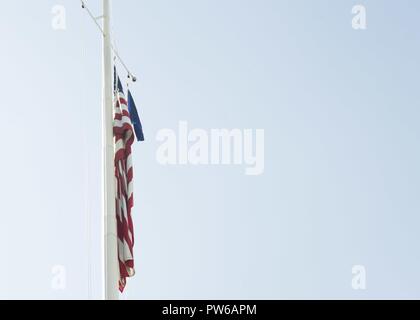 WASHINGTON (Oct. 2 2017) The United States ensign flies at half-staff on the Washington Navy Yard to honor victims of the Oct. 1 mass shooting in Las Vegas. President Donald J. Trump directed that all flags be flown at half-staff until sunset, October 6. Stock Photo