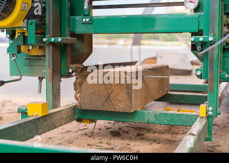 Sawmill. Process of machining logs in equipment sawmill machine saw saws the tree trunk on the plank boards. Wood sawdust work sawing timber wood wood Stock Photo