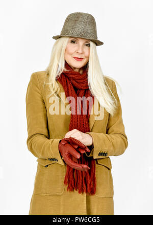 Attractive Caucasian woman in winter clothing putting a red pair of gloves on