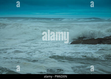 huge white capped waves rolling in from the atlantic ocean under a storm cloud filled sky. Stock Photo