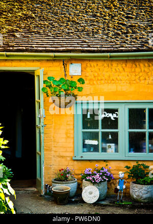 partial view of old cottage colorfully painted in bright colors with moss covering on the roof Stock Photo