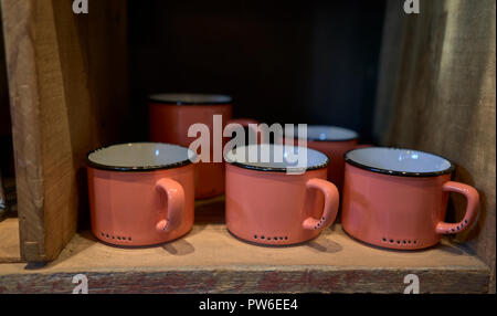 Orange metal cups on a shelf Stock Photo