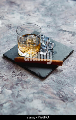 Glass of whiskey with ice cubes and cigar Stock Photo