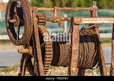 Winch rusty old boat winch for pulling boats up the beach at Seaford head. Open to the elements and salt water the iron and steel has heavy corrosion Stock Photo