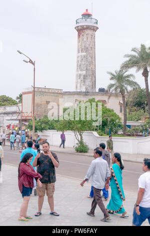 People walking in front of a lighthouse in pondicherry Stock Photo