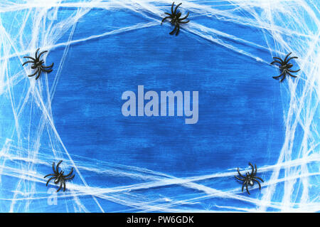 Halloween background. Spider web and spiders as the symbols of Halloween on the dark blue wooden background. Halloween festive card with free space fo Stock Photo