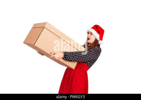 Portrait of excited surprised girl in dress holding big and heavy gift box. isolated on white background. holidays concept. Stock Photo