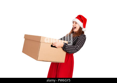 Portrait of excited surprised girl in dress holding big and heavy gift box. isolated on white background. holidays concept. Stock Photo