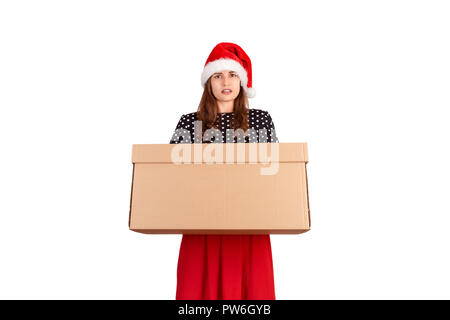 Portrait of excited surprised girl in dress holding big and heavy gift box. isolated on white background. holidays concept. Stock Photo