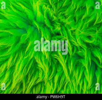 Modern neon green colored soft hairy fur on a animal skin carpet macro closeup texture background Stock Photo