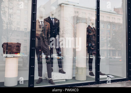 Manikins dressed in autumn male outfits on showcase of a store in city center. Shopping and sales concept. Black friday Stock Photo