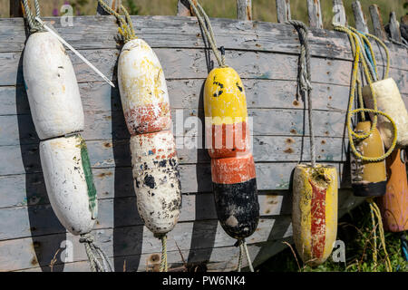 Buoys hanging from the side of an old weathered abandoned fishing boat in a junkyard on the Homer Spit Alaska Stock Photo