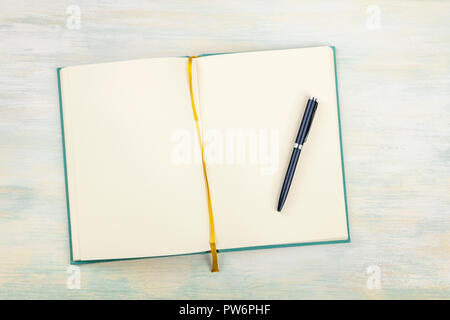 A top shot of an open journal with a pen on a light background with a place for text Stock Photo