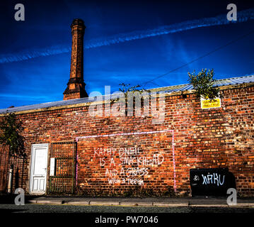 Graffiti on a brick wall of a factory in a back street of Birkenhead in Merseyside, northern England. Stock Photo