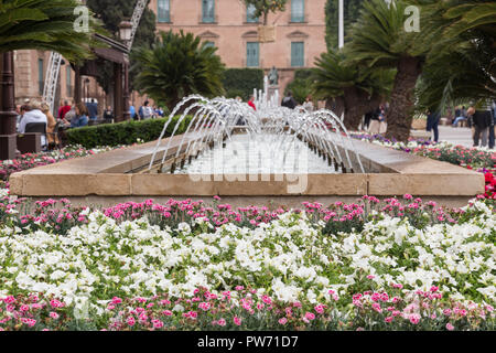 view of a fountain of jets in the town hall square of Murcia, decorated with flowers for the spring festival, Spain Stock Photo